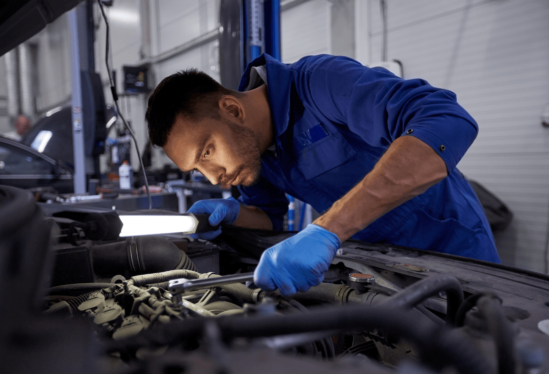 A mechanic working on a car, protected by his motor trade insurance, tailored to his needs.