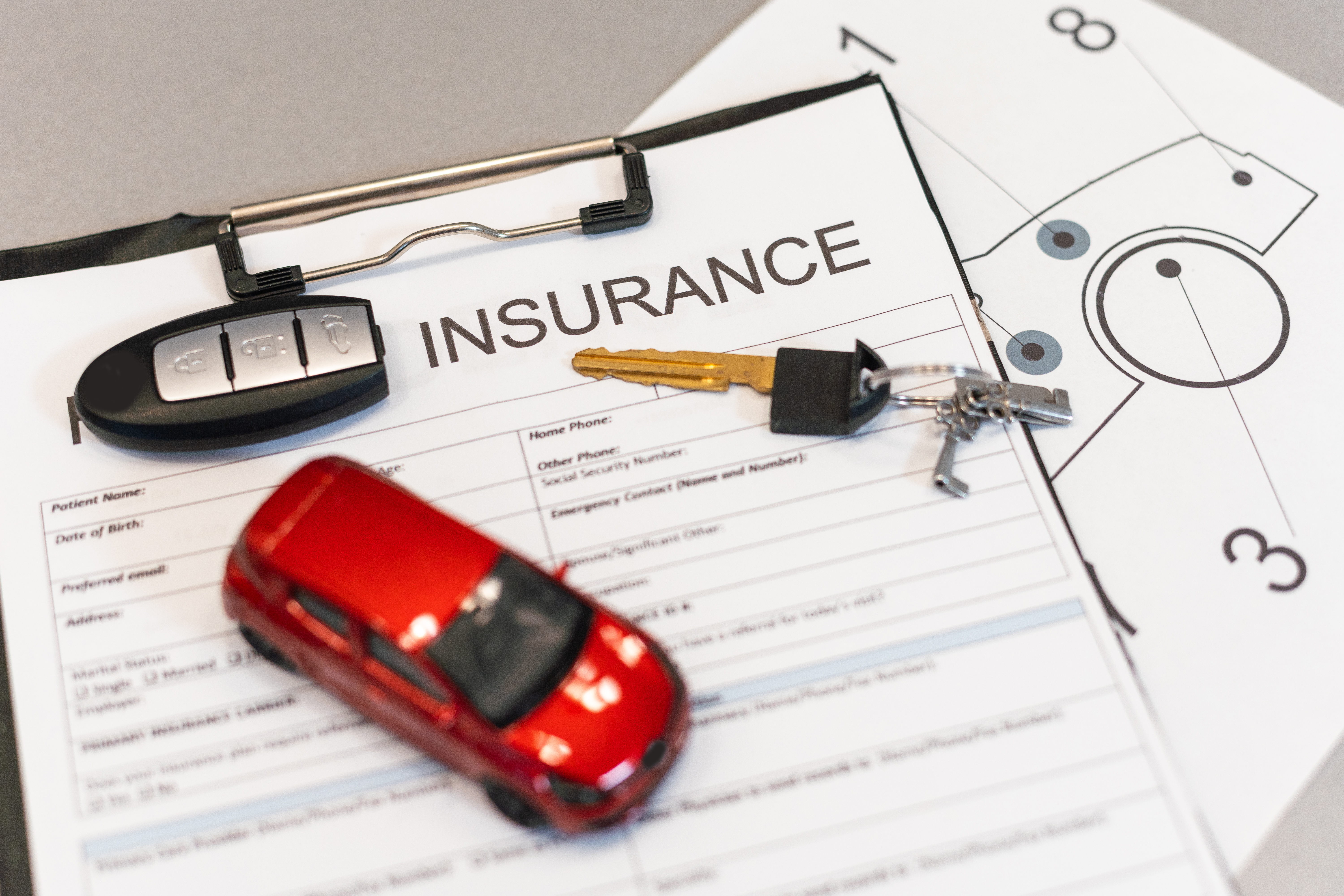 Car keys and insurance documents illustrating public liability and personal accident insurance cover for small trade businesses.